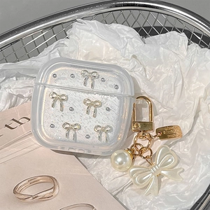 Detail of translucent frosted AirPods case with pearl bow charm and gold keychain