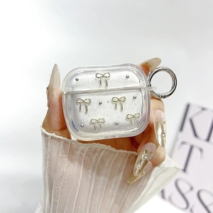 Dettaglio custodia AirPods Pro glitterata con fiocchi in metallo e gancio portatile