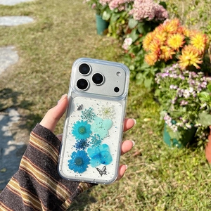 Close-up of clear iPhone case with real blue flowers, silver glitter, and butterfly detail