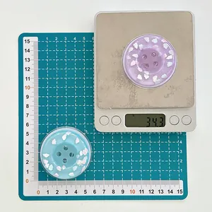 Measurement of light blue button phone grip on an electronic scale showing 34.3g weight