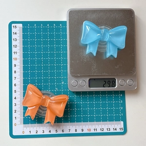 Detail showing solid color bow-shaped phone grip weight of 29.8g and width of 5.5cm