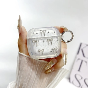Dettaglio custodia AirPods Pro glitterata con fiocchi 3D argento e moschettone