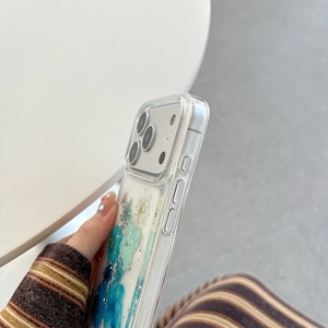 Detail of transparent iPhone case with real blue and white dried flowers and glitter