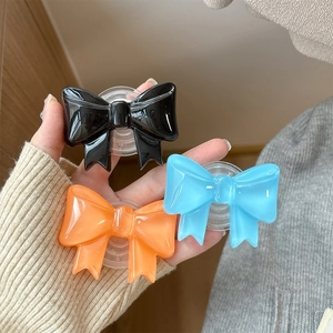 Minimalist solid color bow knot phone grip stand in black, blue and orange colors