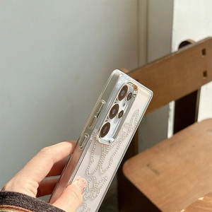 Detail showing pearl rhinestone butterfly pattern and metal lens frame on phone case