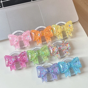 Detail of colorful bow phone grips with sparkling heart sequins on white card