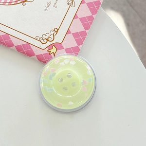 Detail of light green button-shaped phone grip with colorful cloud-like glitter sequins