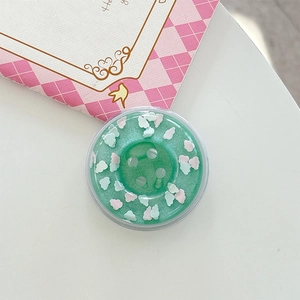 Macro shot of mint green donut phone grip with resin clouds and glitter details
