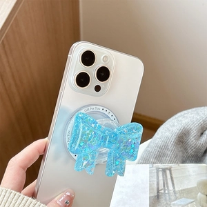 Close-up of blue sequin bow phone grip holder with Gift For You print on white iPhone