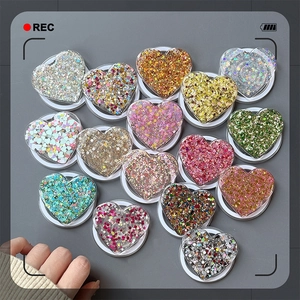Flat lay of diverse heart-shaped glitter phone grips in various sparkling colors