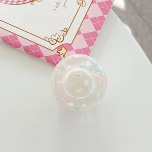 Close-up of a clear resin button with pink and blue clouds for phone grip decor