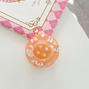 Close-up of translucent orange heart sequin pop socket phone grip with 4-hole button design