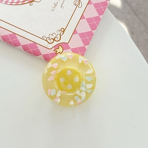 Detail of yellow resin button featuring colorful cloud sequins and a four-hole design