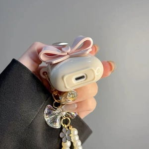 Detailed cream AirPods 4 case with pink 3D bow and elegant pearl flower pendant strap