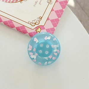 Macro shot of a cute light blue resin phone grip with clouds and fine glitter