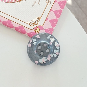 Macro shot of grey resin phone grip with glitter clouds and classic four-hole design