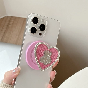 Detail of pink leather heart phone grip with rhinestone border and silver bear emblem