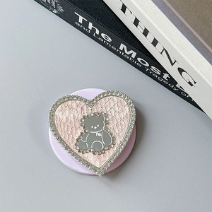 Detail of pink snake leather heart phone grip with rhinestone bear mirror and gems