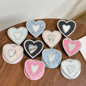 Rhinestone heart phone grip with faux leather texture on a wooden table display
