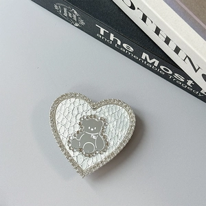 Detail of heart-shaped magnetic phone grip with white crocodile leather and rhinestones