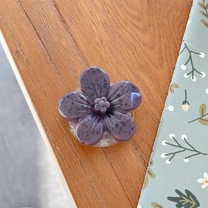Detail of purple 3D flower phone socket with stone texture and transparent base