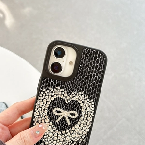 Detail of black snakeskin texture iPhone case with rhinestone heart and bow design