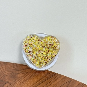 Detail of heart-shaped phone griptok with yellow resin and gold glitter sequins
