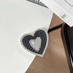 Macro view of heart-shaped phone grip with crocodile leather and rhinestone detailing