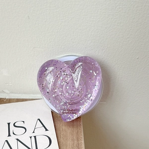 Détail du support de téléphone cœur à paillettes violettes avec base magnétique sur fond