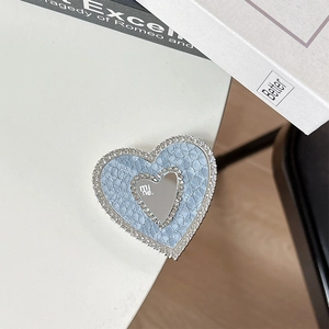 Detail of light blue heart phone grip with rhinestones and a mirror featuring mine text