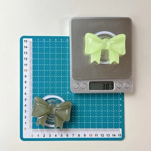 Detailed scale view of two solid color bow magnetic phone grips weighing 38.7g each