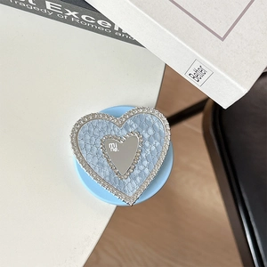 Close-up of light blue heart phone grip with sparkling rhinestones and a center mirror