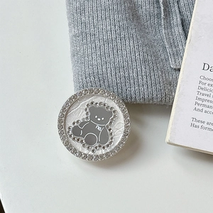 Detailed close-up of a magnetic phone grip featuring a crystal-encrusted gray bear mirror