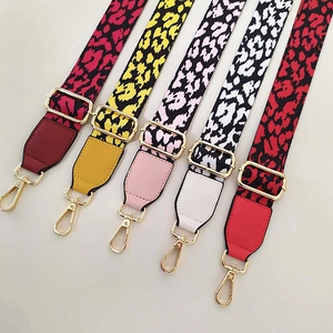 Macro shot of colorful leopard print bag straps with leather ends and gold metal hooks