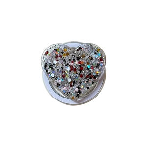 Sparkly heart-shaped phone grip with colorful glitter and white foldable base