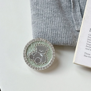 Macro shot of mint green magnetic bear phone grip with sparkling rhinestone details