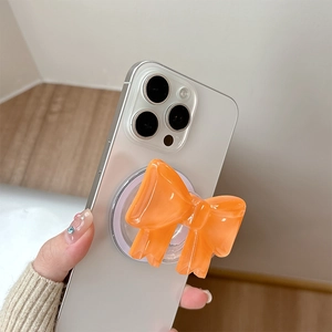 Orange bow MagSafe phone grip stand with glossy resin finish for easy handheld use