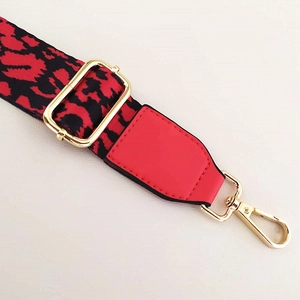 Close-up of red leopard jacquard wide bag strap with gold metal lobster clasp