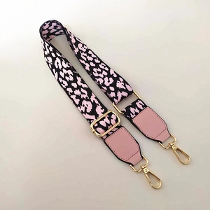 Detail of pink and black leopard jacquard strap with gold hardware and leather ends