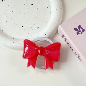 Close-up of a glossy red translucent bow magnetic phone grip on an aesthetic tray