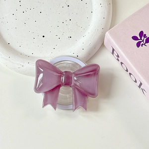 Macro detail of purple bow phone grip on ceramic tray with elegant aesthetic display