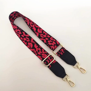 Detail of red and black leopard print wide bag strap with gold metal swiveling hooks