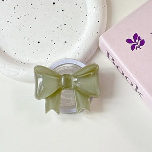 Macro detail of glossy green ribbon phone grip with a retractable MagSafe base