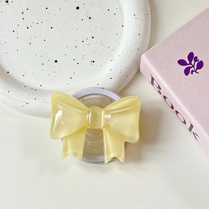 Detail of light yellow resin bow phone holder with a smooth pearlescent texture