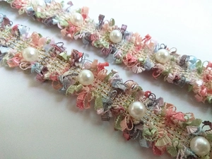 Detail of colorful lace bag strap with white pearls and gold wire embroidery