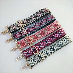 Close-up of adjustable ethnic jacquard bag straps with golden swivel hooks and buckles