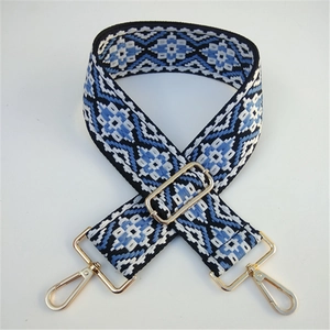 Detail view of ethnic embroidery guitar style wide strap with gold metal lobster clasps