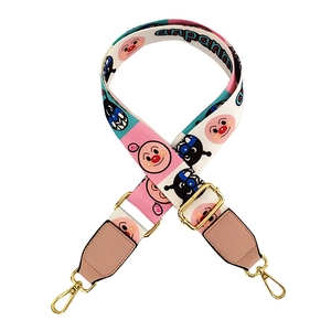 Close-up of adjustable wide woven strap featuring cartoon Anpanman pattern with gold hardware