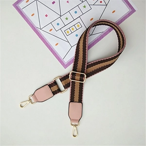 Detail of adjustable striped shoulder strap with gold metal hooks and pink leather accents