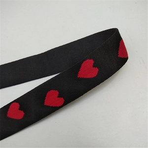 Detailed view of adjustable nylon strap with red heart pattern and diagonal twill texture